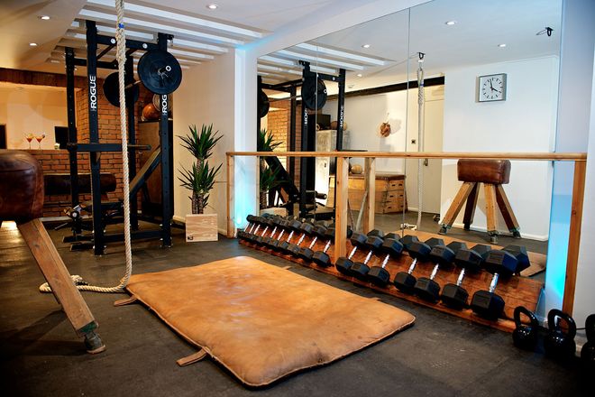Private home gym with reclaimed timber walls, London — the kind of room the Mirror is designed for