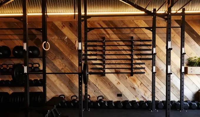 Dark timber training room with a rig and wall bars