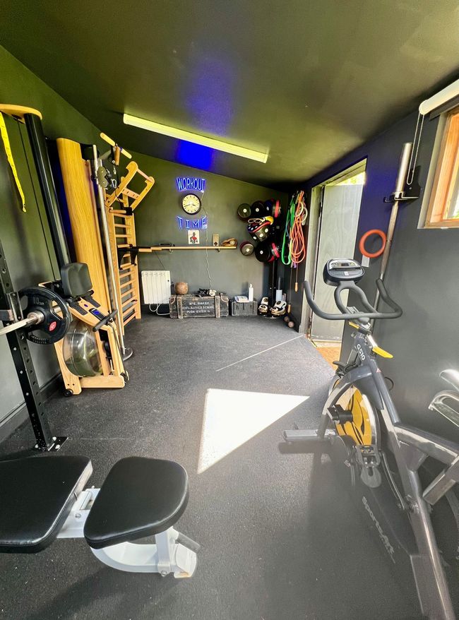 Private gym with a skylight, exercise bike and free weights